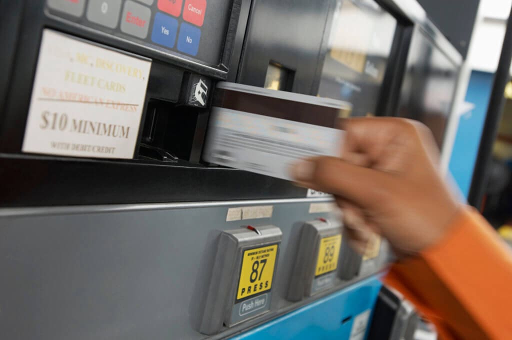 Person paying with credit card at gas pump, motion blur